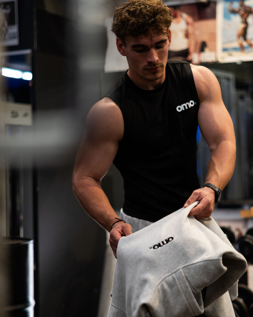 Model trägt omo Compression Tank Top Schwarz und Essential Jogger Grau im Gym