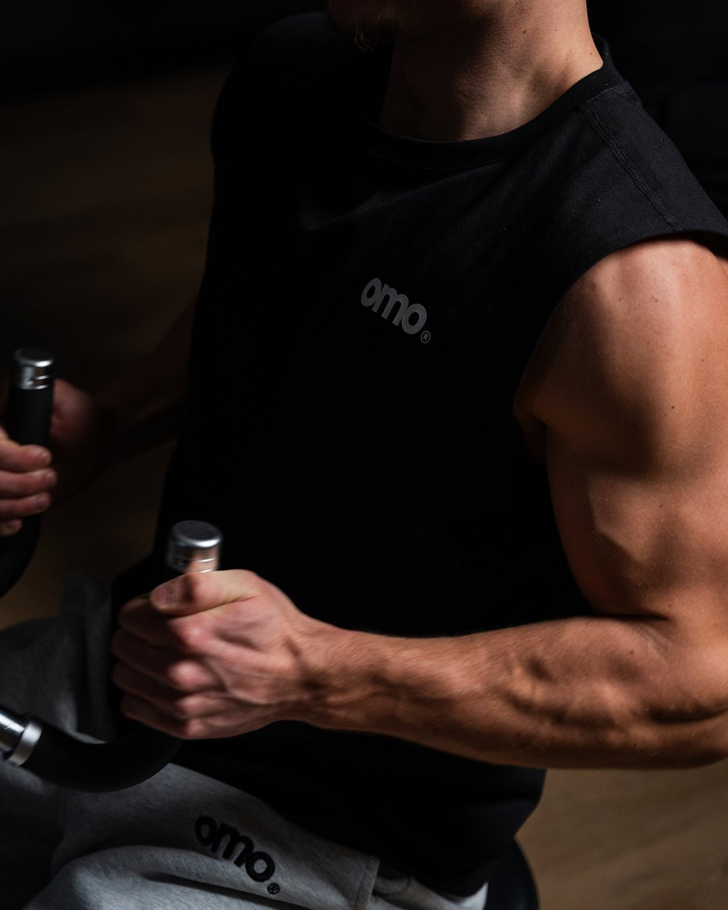 Model trägt omo Gym Tank Schwarz und Essential Jogger Grau beim Training